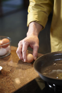 a cook cracks an egg