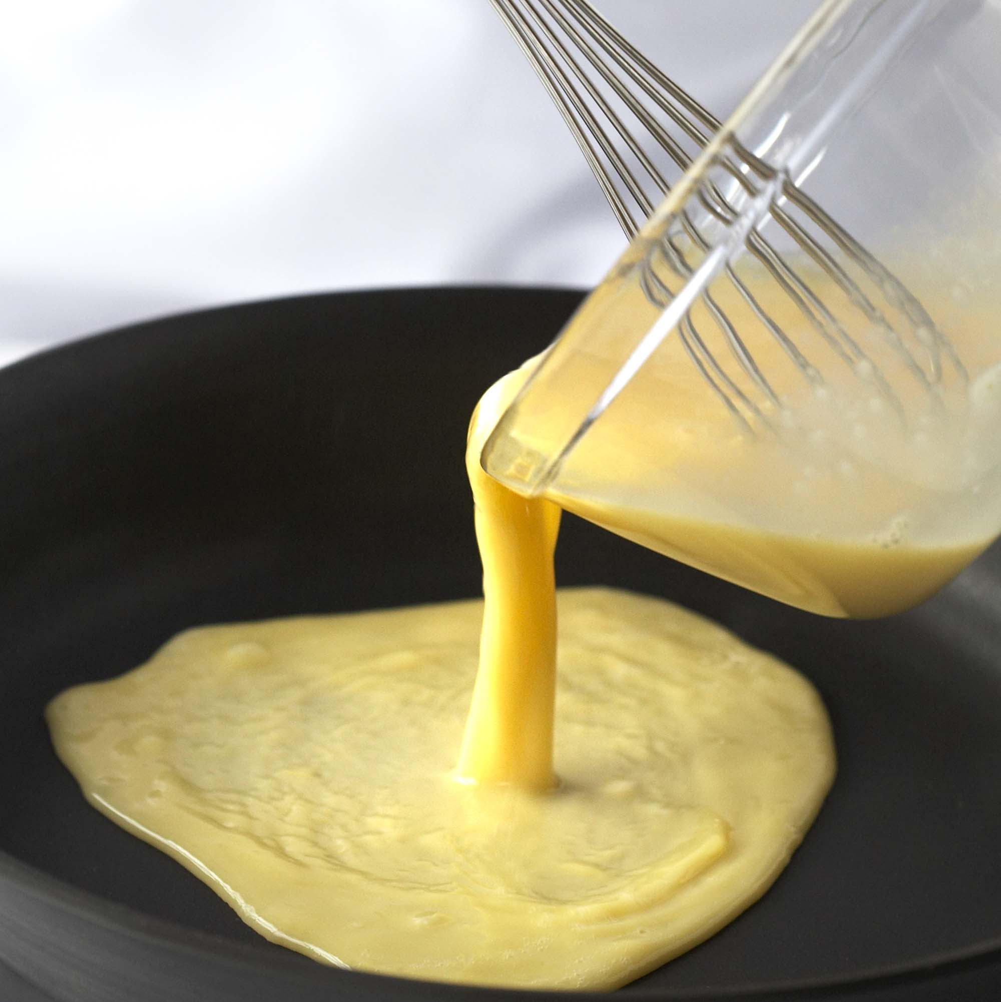 pouring eggs into a pan