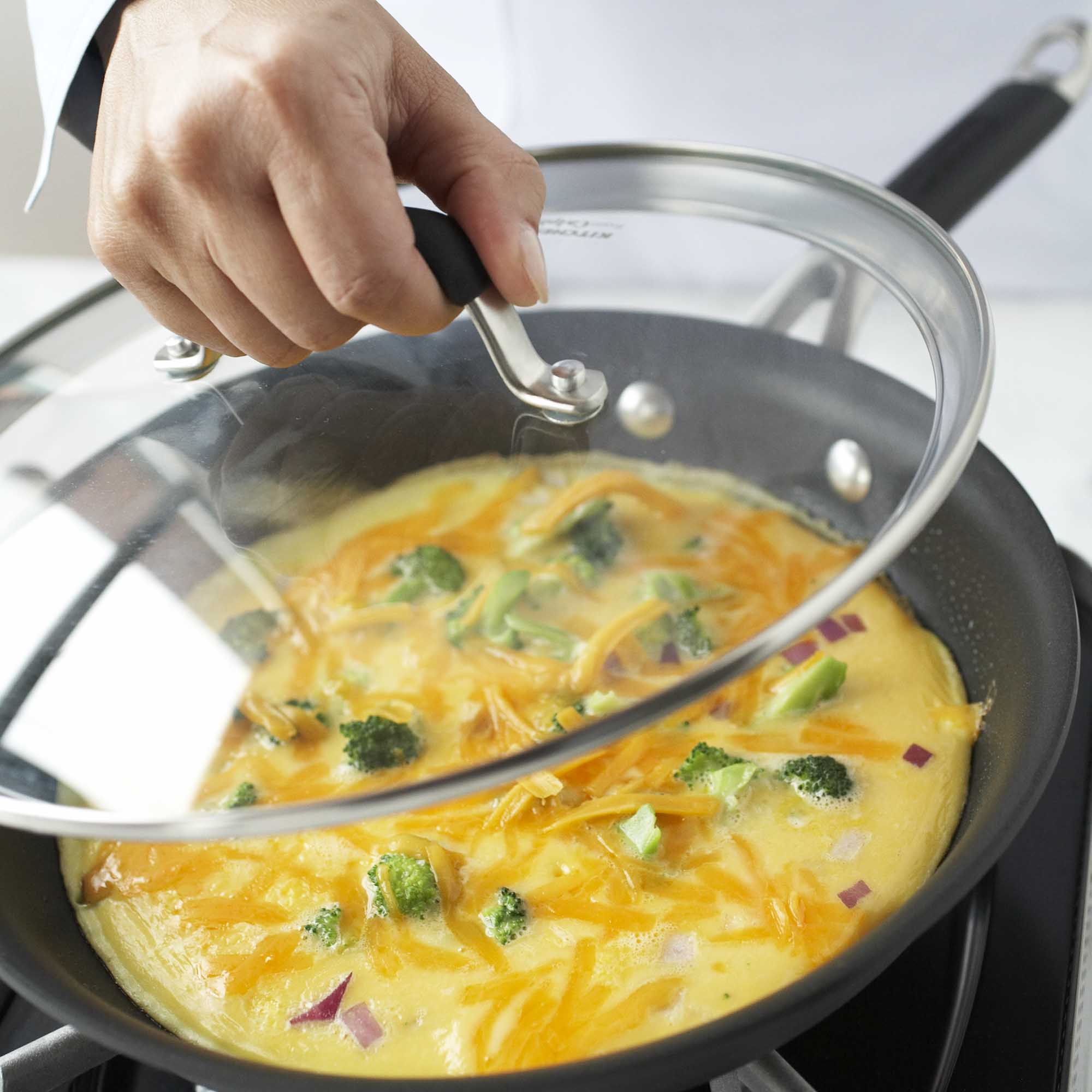 putting a lid over a cooking frittata