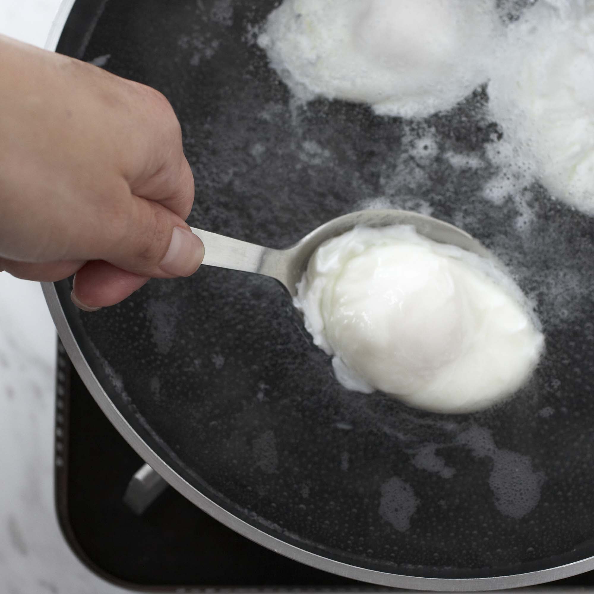 scooping egg out of boiling water