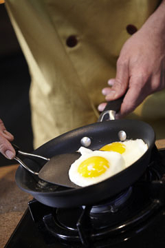 a cook removes cooked eggs from a pan