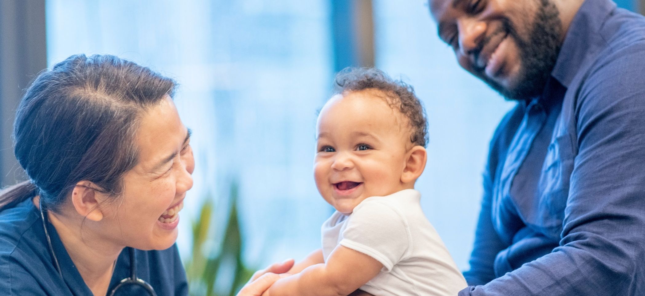 a baby smiles at a nurse