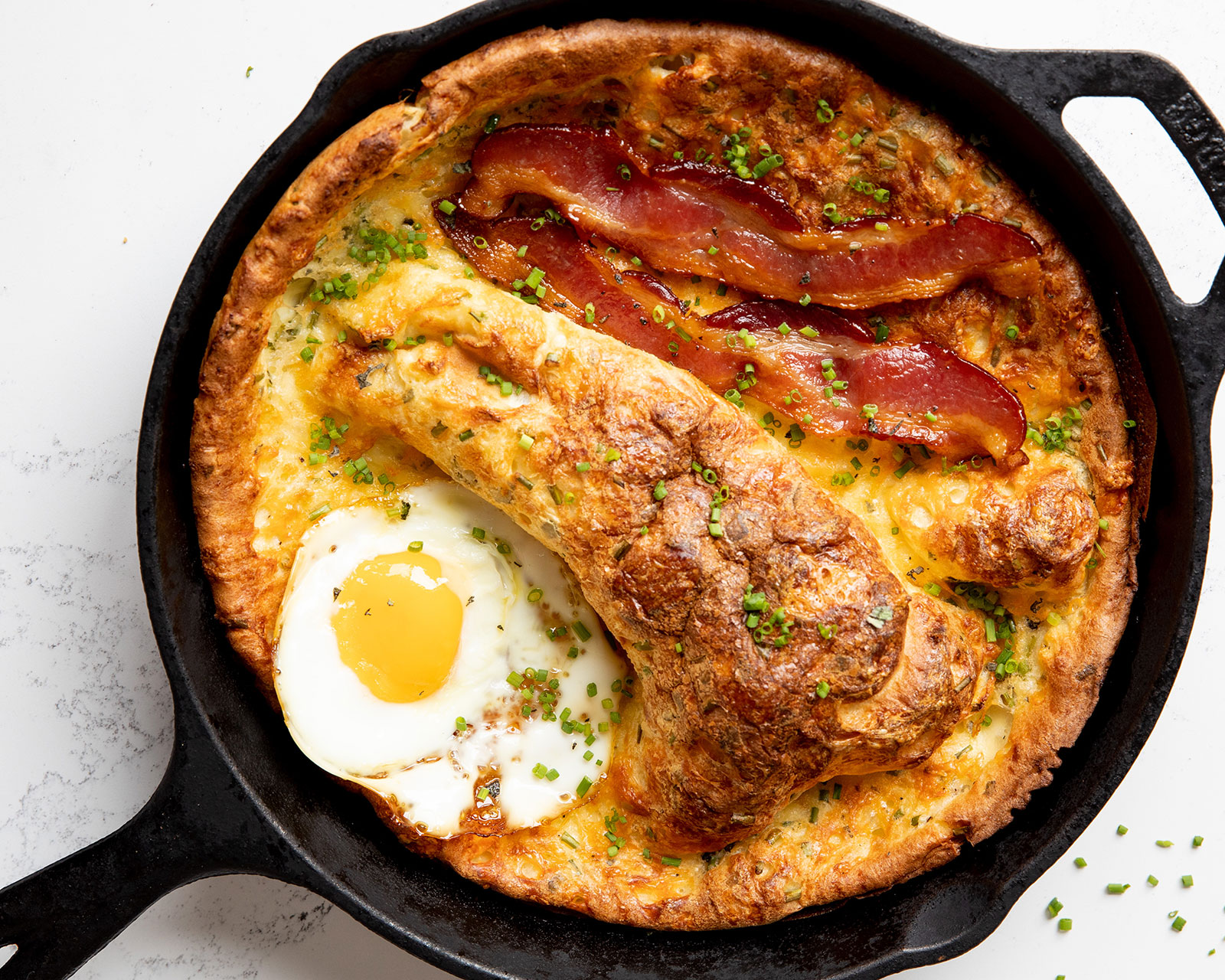 Smoked Cheddar Dutch Baby with Maple Bacon and Fried Eggs