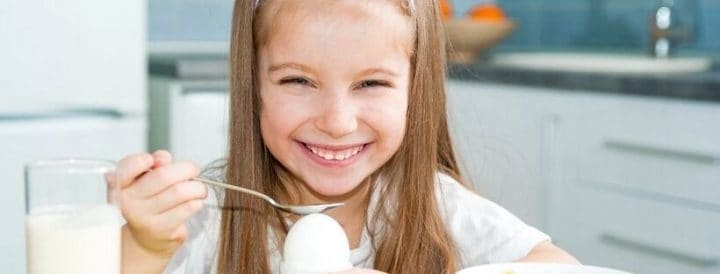 smiling girl holding a spoon
