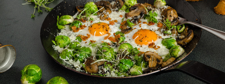 a skillet of eggs, brussels sprouts, and mushrooms