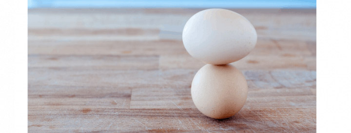 an egg balanced atop another egg