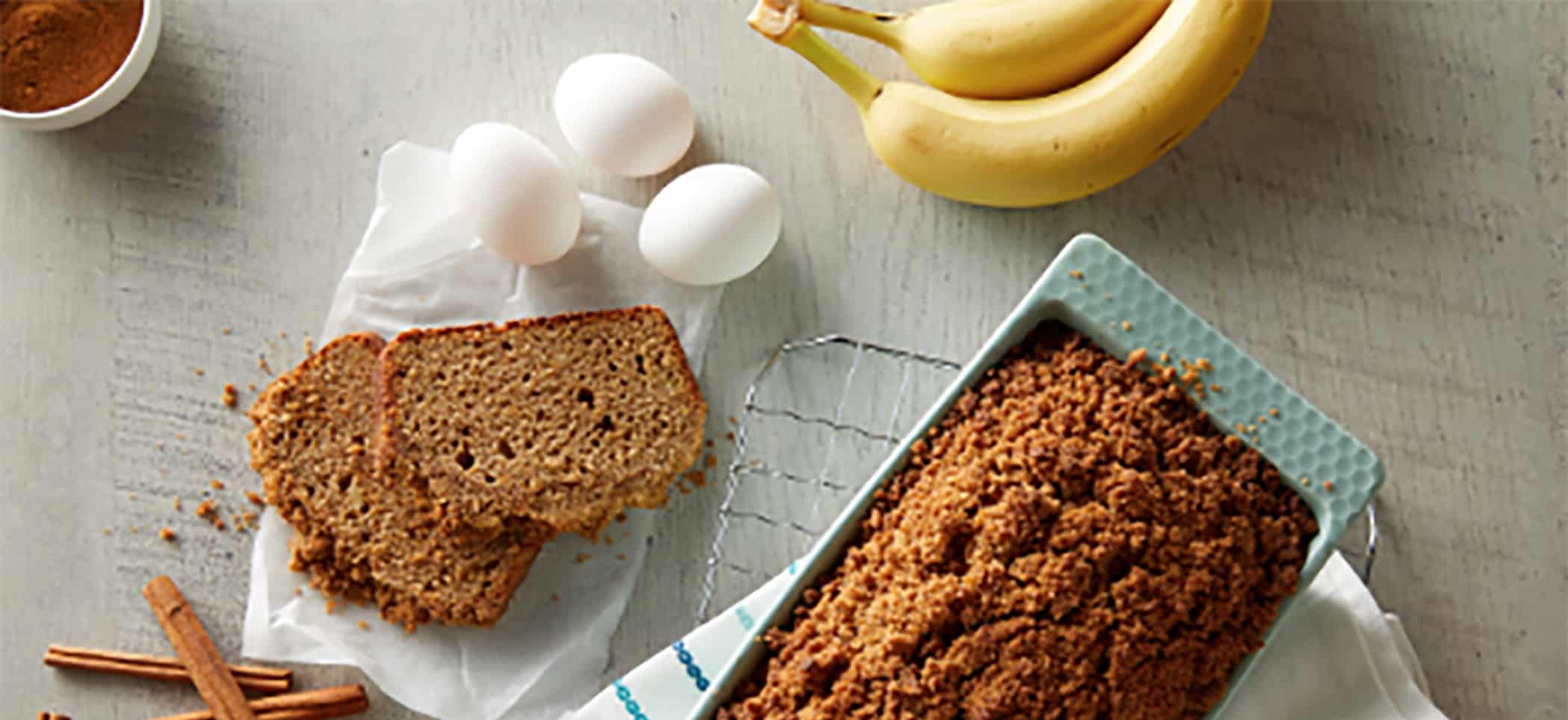 banana bread next to eggs and bananas