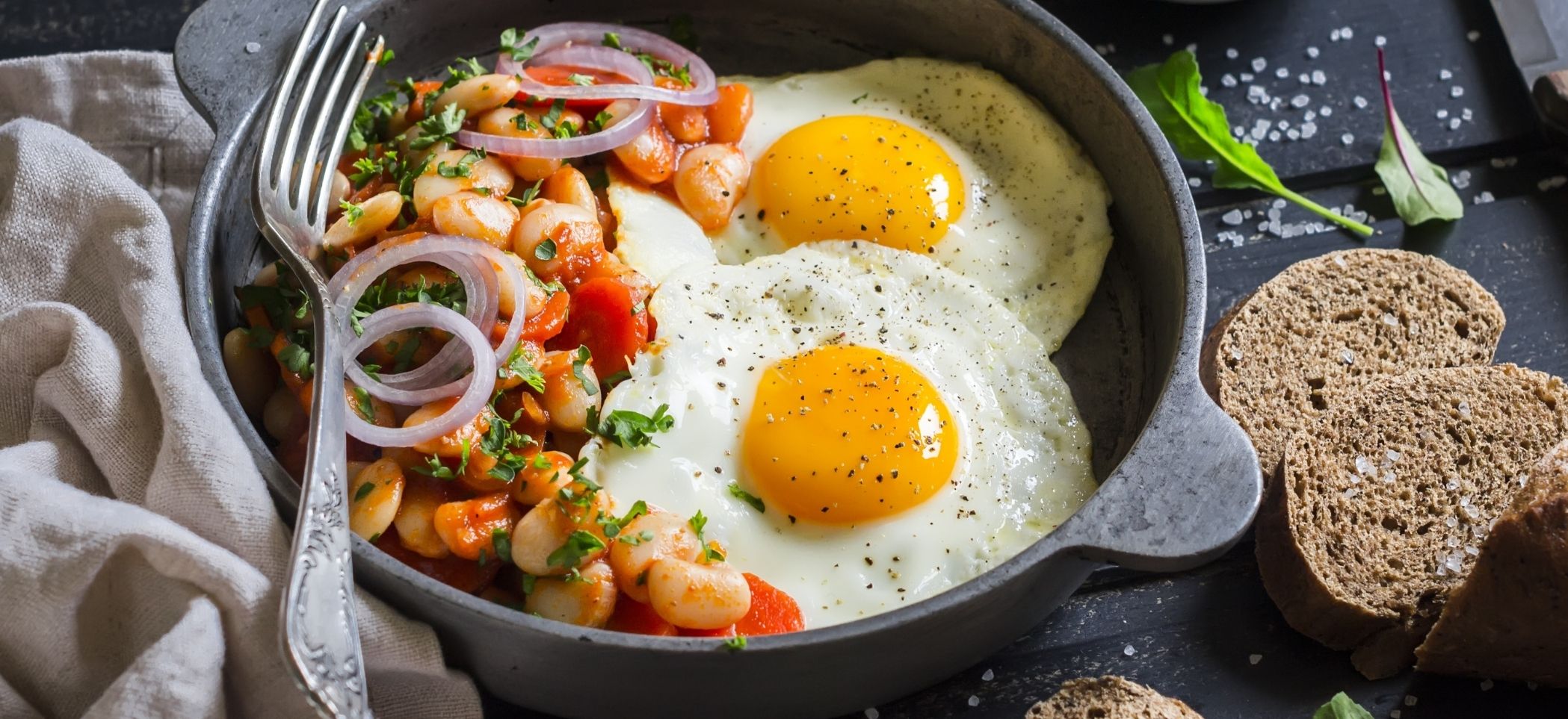 eggs in a skillet with onions and beans