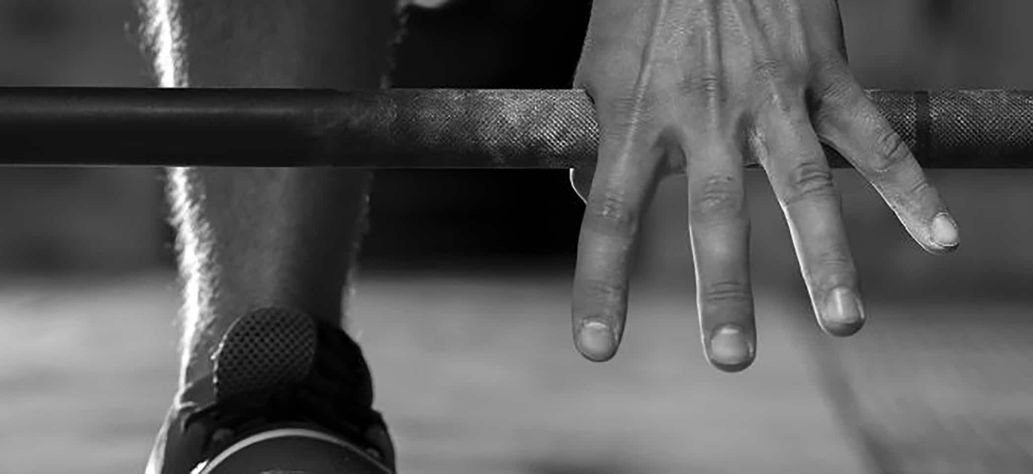 a hand on a barbell
