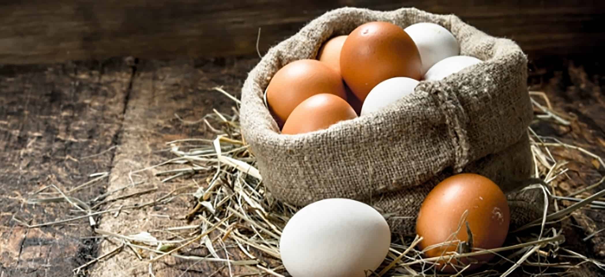 eggs in a burlap sack sitting on straw and wooden slats