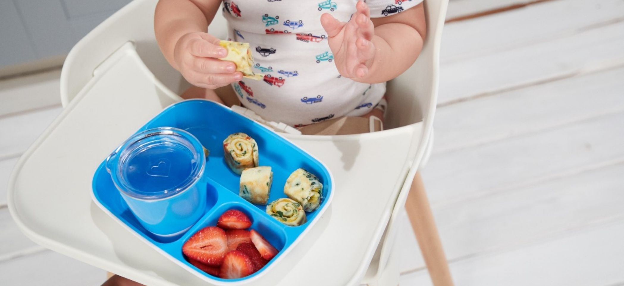 a child sits in a highchair and eats food