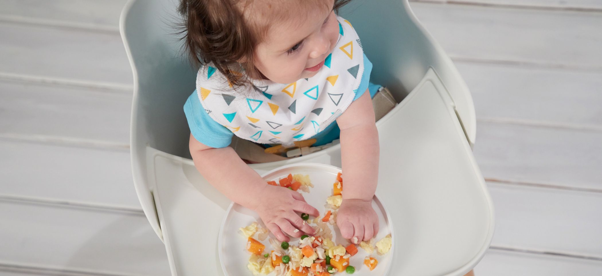 a child in a highchair eating food