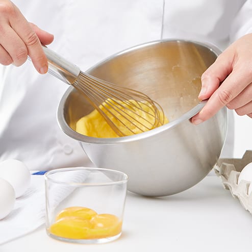 a chef whisks eggs in a bowl
