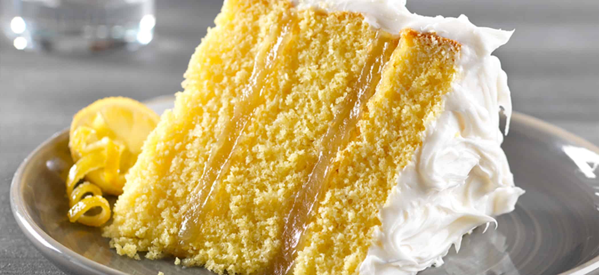 a slice of yellow cake with white frosting