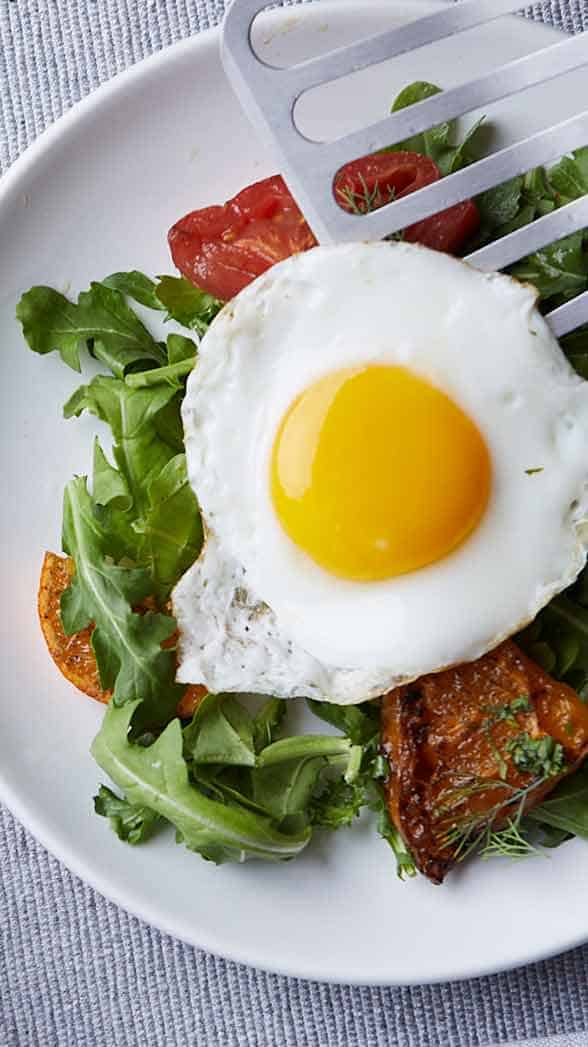 a fried egg on a bed of greens