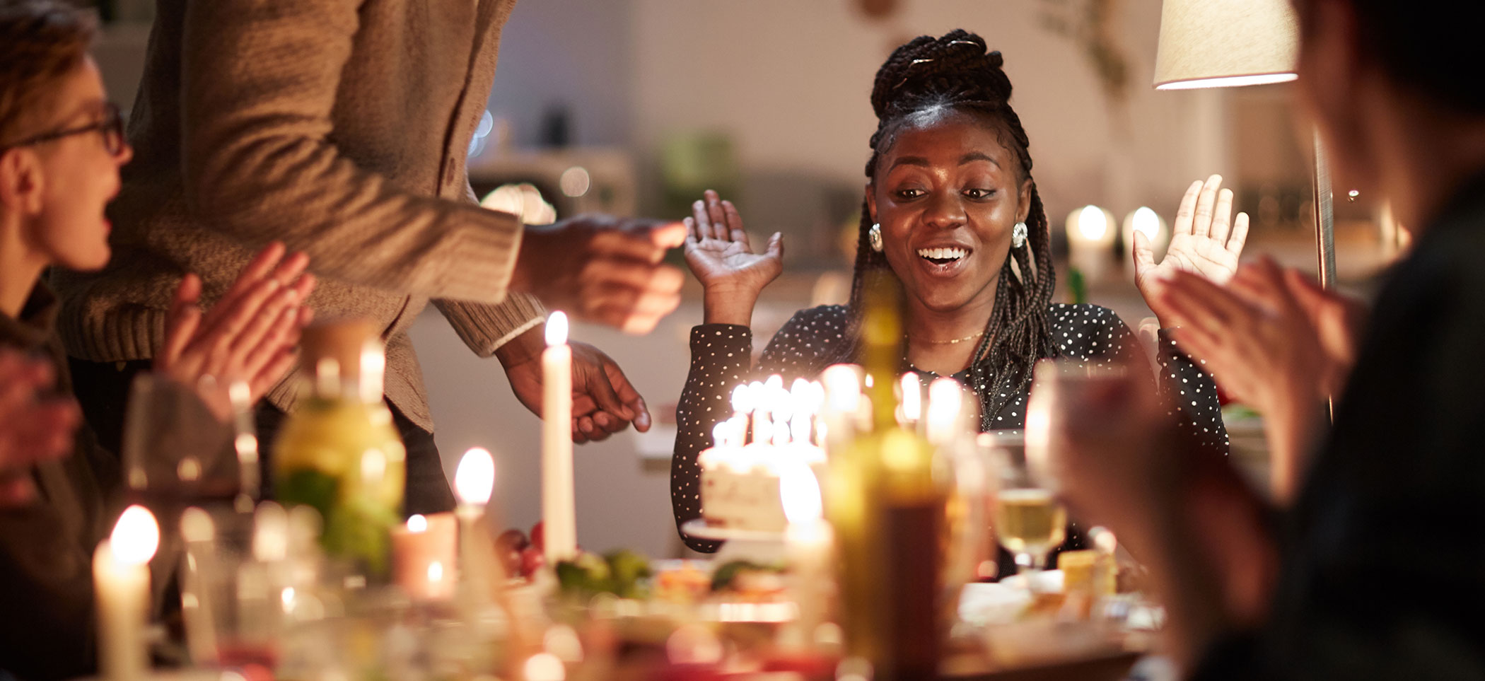 a woman celebrates with a birthday cake