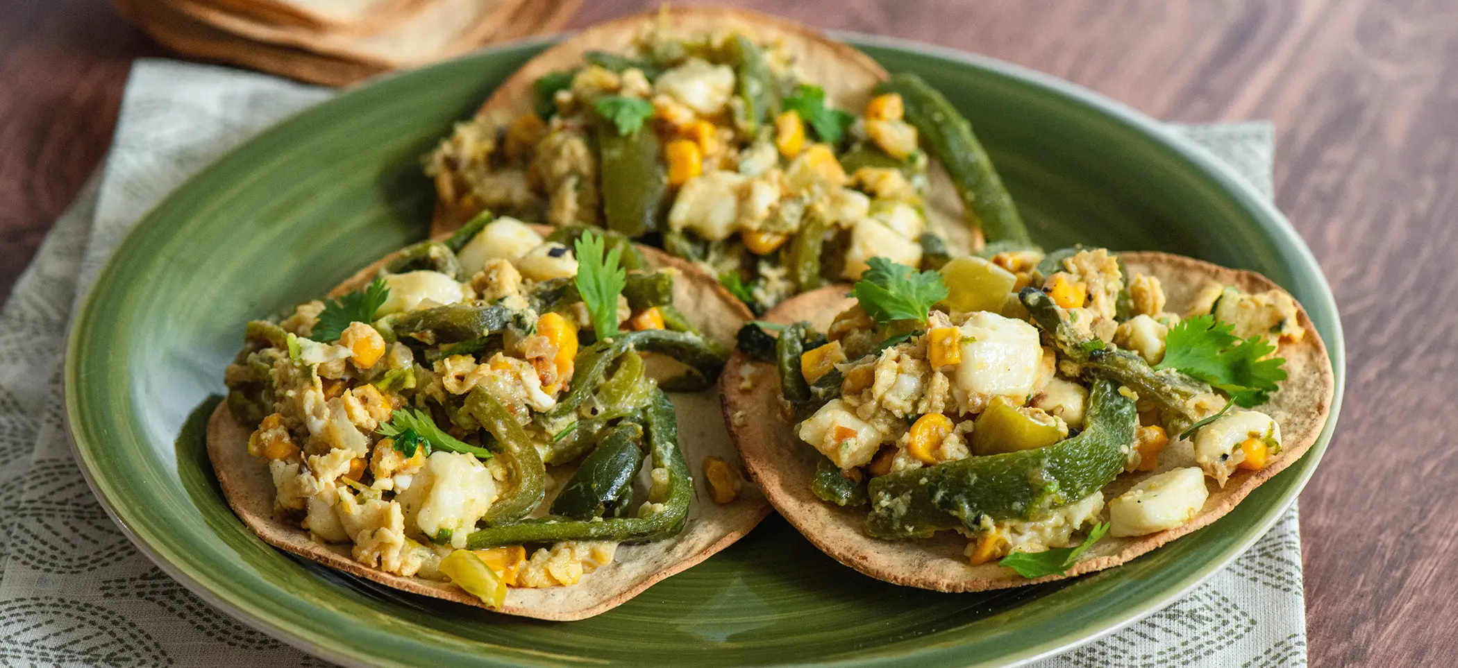 Platillo de rajas y revuelto de maíz en tostadas