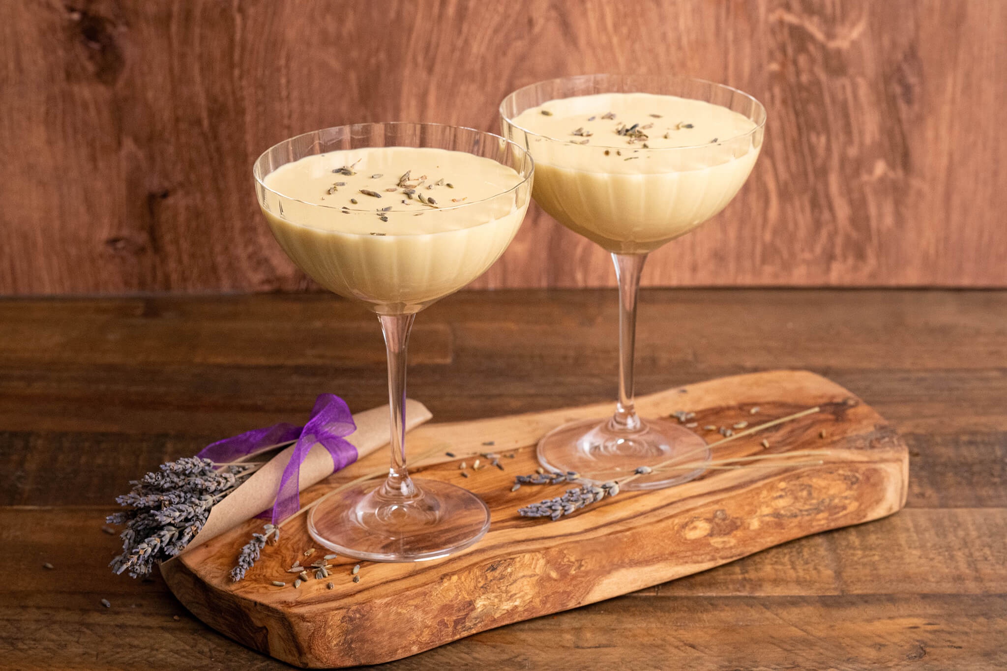 Two glasses of Botanical Garden Eggnog on top of a wooden board